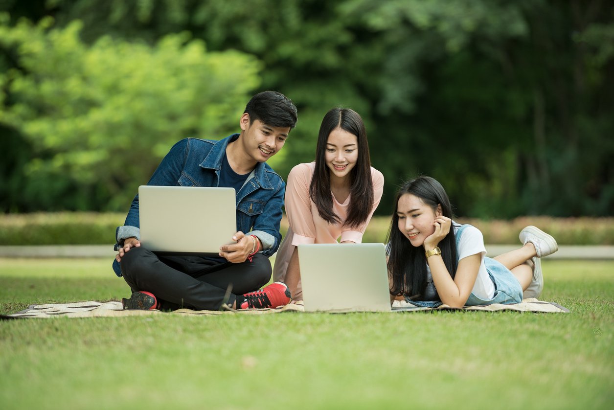 Friends Using Laptops in the Park